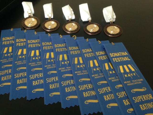 Blue ribbons and gold medals are displayed from a judged festival.