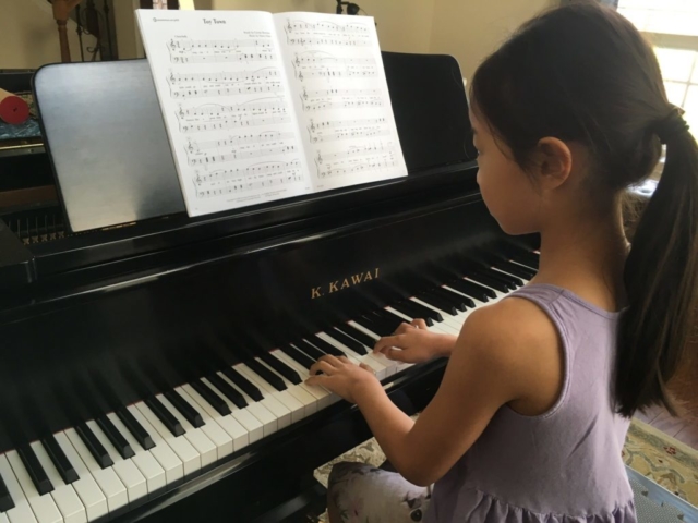 Girl playing the grand piano.