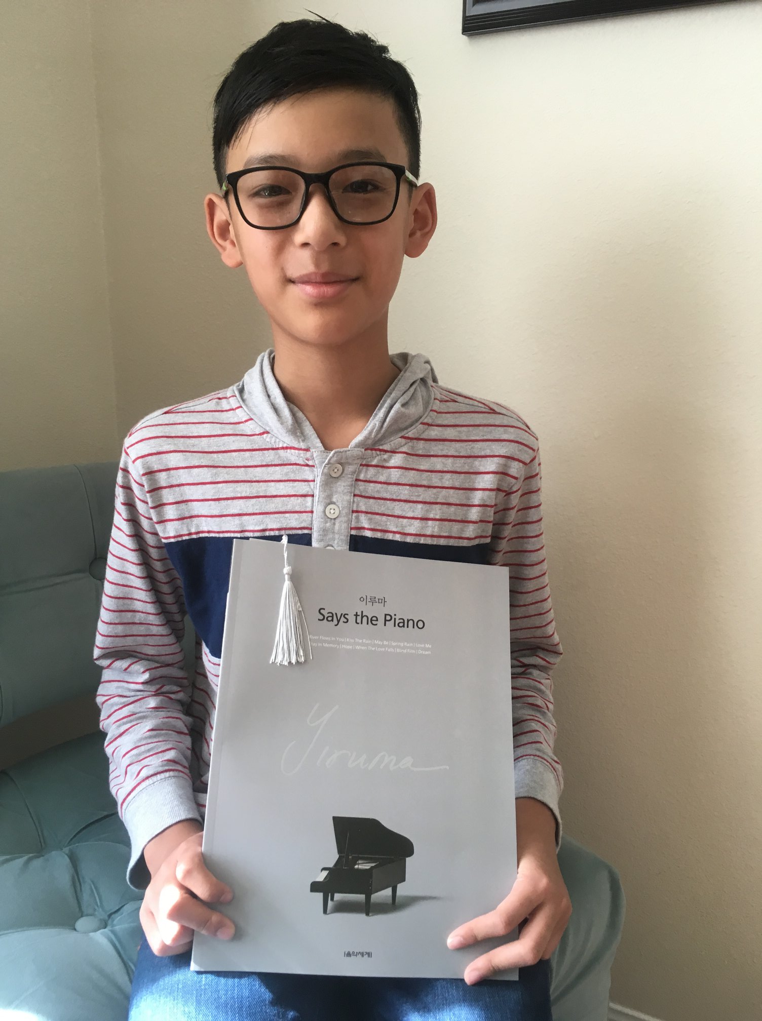 Teenage boy holds a book of Yiruma’s compositions.